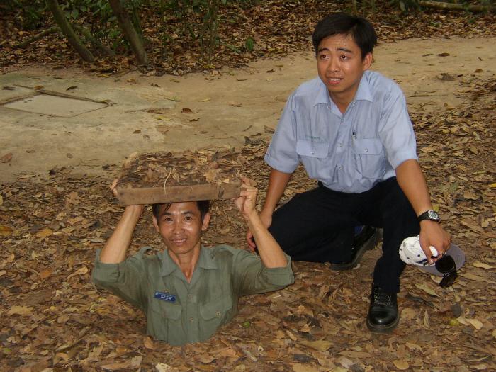 Tam And Tour Guide Demonstrating Entrance (Cu Chi Tunnels)